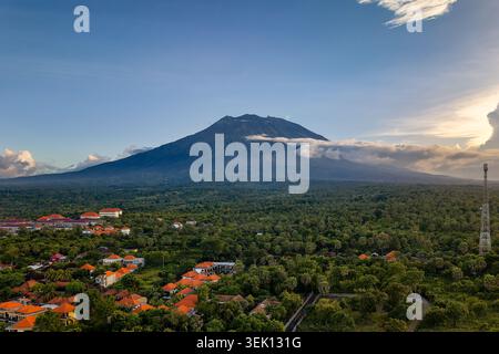 Volcan Mont Agung dominant une forêt tropicale luxuriante et village à Bali Banque D'Images