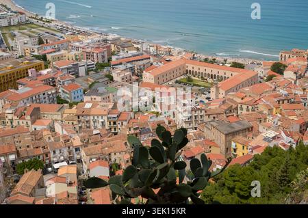 Une vue aérienne de la ville côtière de Cefalù, Sicile. L'image capture l'architecture dense et historique à toit rouge et la mer, montrant le BE Banque D'Images