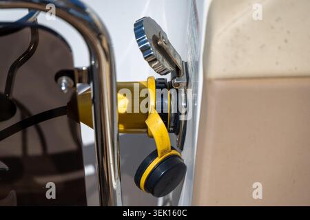 Vue détaillée d'un point de connexion électrique maritime sur un bateau, montrant la fiche jaune et son mécanisme de verrouillage sécurisé Banque D'Images