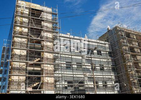 Batumi, Géorgie - 30 mai 2026 : chantier de construction moderne avec bâtiment de grande hauteur couvert par des échafaudages métalliques et des escaliers. Banque D'Images