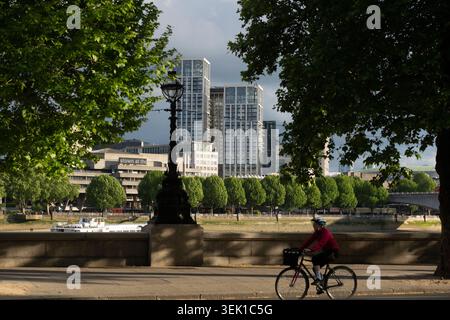 Un cycliste longe la rive nord de la Tamise à Londres, avec le Royal Festival Hall et South Bank place en arrière-plan. Banque D'Images