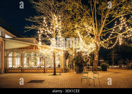 Amsterdam, pays-Bas - 18 avril 2026 : vue en soirée sur la terrasse et les arbres illuminés de l'Hotel Arena près d'Oosterpark à Amsterdam, pays-Bas, w Banque D'Images