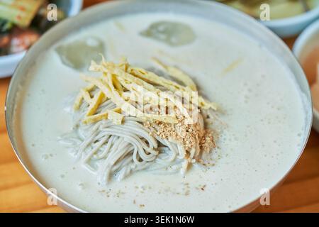 Coréen Memil Kongguksu, nouilles froides de sarrasin dans un bouillon crémeux de soja. Garni d'œufs et servi avec des accompagnements pour un repas d'été sain. Banque D'Images