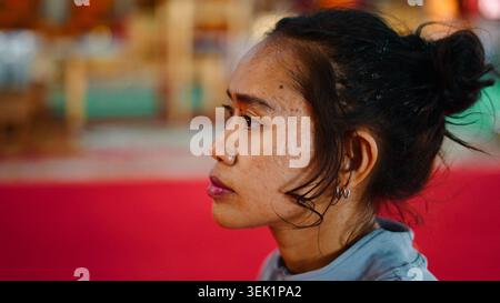 Jeune femme asiatique en pause, montrant introspection et identité culturelle Banque D'Images