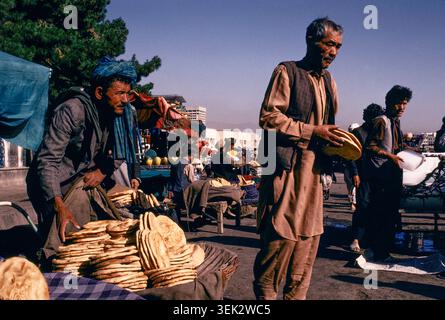 Commerçants de rue vendant du pain plat traditionnel naan tôt le matin, Kaboul, Afghanistan, août 1992. Banque D'Images