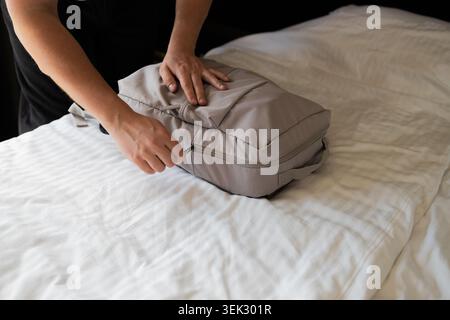 Emballage sac à dos gris sur le lit préparation pour le voyage de voyage Banque D'Images