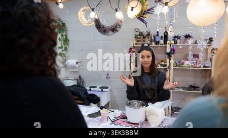 Femme dirigeant un atelier créatif, expliquant le processus de fabrication de bougies Banque D'Images