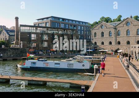 Bateau-maison de barge de canal traditionnel amarré à la marina historique de Bristol Harbourside par des immeubles d'appartements en briques de pierre en bord de mer à Bristol, Royaume-Uni Banque D'Images