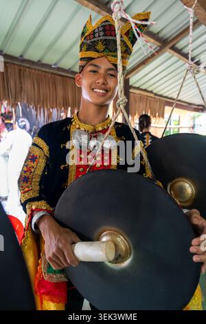 Jeune homme jouant au gong portant du sinipak pendant le festival de moisson Kaamatan à Sabah Banque D'Images