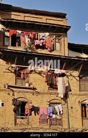 Cordes à linge, cordes à linge, cordes à linge avec linge coloré attaché à la façade d'un bâtiment local traditionnel dans la vieille ville de Bhaktapur Banque D'Images