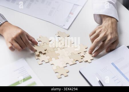 Mains d'homme d'affaires mettant ensemble des pièces de puzzle avec Team Building Join Together et Business collaboration concept dans le bureau Banque D'Images