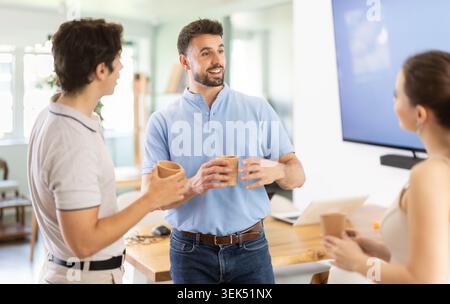 Pause café - groupe d'employés de bureau buvant du café et discutant les uns avec les autres pendant la pause Banque D'Images