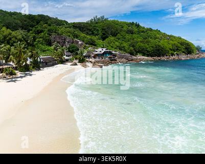 Vue aérienne sur la plage de sable et l'océan avec vagues. Seychelles, Mahé. Anse Takamaka Beach. Banque D'Images