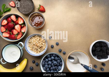 Ingrédients sains pour le petit déjeuner avec granola de baies de yaourt et miel plat Banque D'Images
