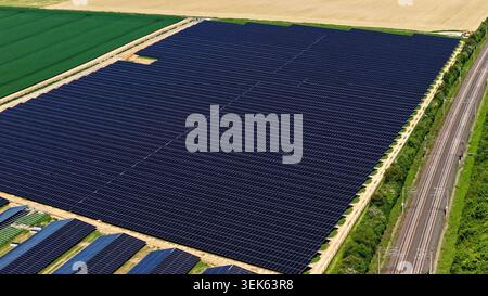 Vaste vue aérienne de ferme solaire dans le paysage rural vert et doré Banque D'Images