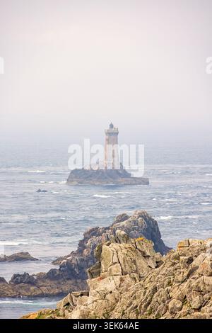 Vue sur le paysage marin par une côte rocheuse avec un vieux phare sur un rocher Banque D'Images