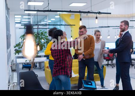 Une photo dynamique d'un groupe diversifié de jeunes professionnels et étudiants travaillant dans un centre créatif moderne et ouvert, examinant des documents et collaborant Banque D'Images
