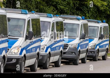 Les véhicules de police se rassemblent lors d'une opération à grande échelle avec des autobus, des motos et des officiers de l'escouade sur place. La scène met en lumière la sécurité publique, les interventions d'urgence coordonnées et la présence des forces de l'ordre en action. Banque D'Images
