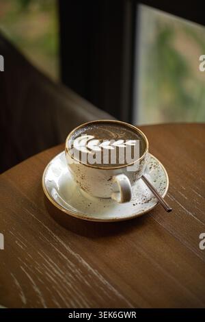 Latte Hojicha avec art latte sur la table Banque D'Images