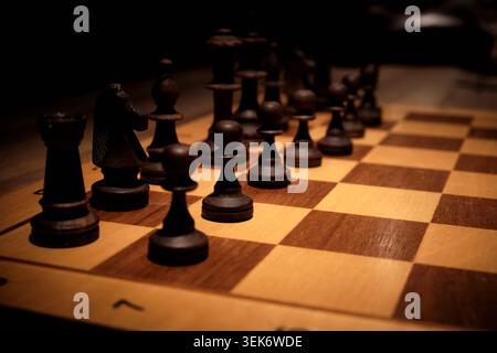 Pièces d'échecs en bois disposées sur échiquier pendant le jeu stratégique Banque D'Images