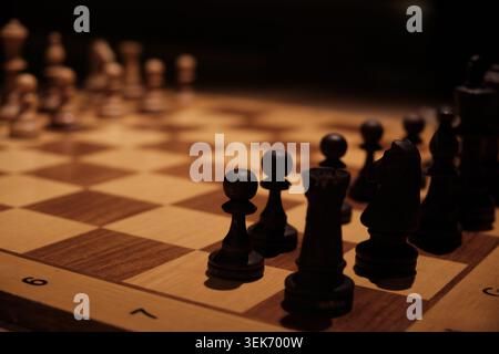 Pièces d'échecs en bois disposées sur échiquier pendant le jeu stratégique Banque D'Images