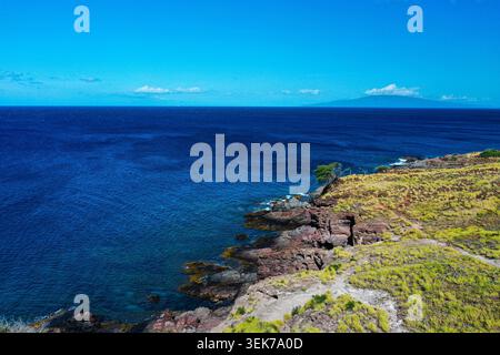 Une vue aérienne panoramique de Maui, Hawaï, mettant en valeur le littoral spectaculaire avec une verdure vibrante, les bords de falaises rocheuses et le Pacifique bleu profond et vaste Banque D'Images