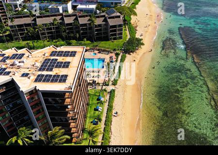 Cette superbe photographie aérienne capture un complexe balnéaire à Maui, Hawaï, mettant en valeur des bâtiments alimentés par énergie solaire, une piscine, une plage de sable doré Banque D'Images