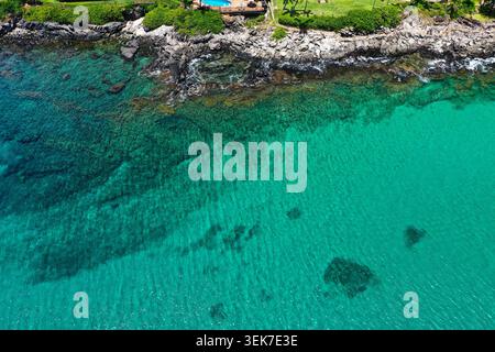 Une vue aérienne à couper le souffle sur la côte de Maui, mettant en valeur les eaux turquoises vibrantes, le littoral rocheux et la végétation luxuriante. La scène capture le Banque D'Images