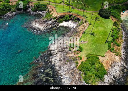 Une vue aérienne époustouflante d'un paysage côtier à Maui, Hawaï, avec des eaux turquoises, des falaises rocheuses, une végétation luxuriante, et parsemé d'un parc bien entretenu Banque D'Images