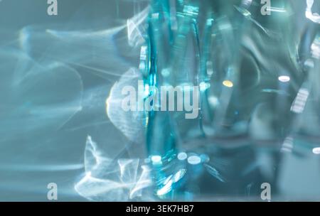 Reflets abstraits de lumière bleue et blanche sur le verre créant des visuels éthérés et dynamiques Banque D'Images