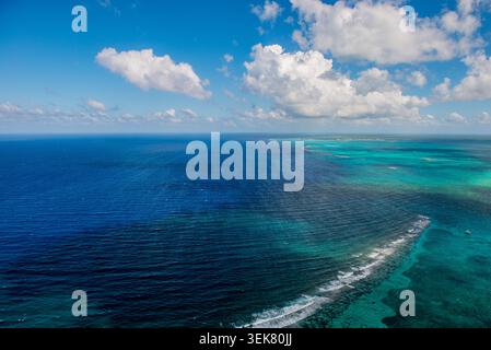 Une photographie aérienne grand-angle capturant la vaste étendue de la mer des Caraïbes bleu profond au large de Grand Caïman, mettant en valeur les eaux turquoises vibrantes Banque D'Images