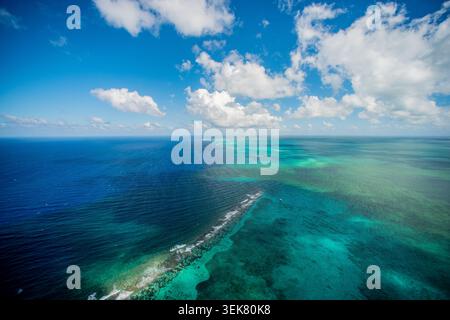 Une photographie aérienne grand-angle capturant la vaste étendue de la mer des Caraïbes bleu profond au large de Grand Caïman, mettant en valeur les eaux turquoises vibrantes Banque D'Images