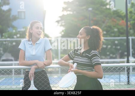 Deux jeunes femmes parlant sur un terrain de pickleball extérieur Banque D'Images