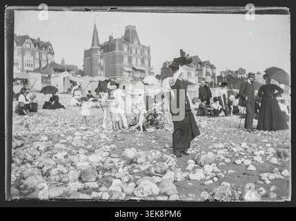 Les vacanciers se tiennent devant la Villa maritime sur la plage du Havre en 1890. La photographie de presse d’Emile Wanhout relate les activités de loisirs et la vie résidentielle côtière sur le rivage normande. Banque D'Images