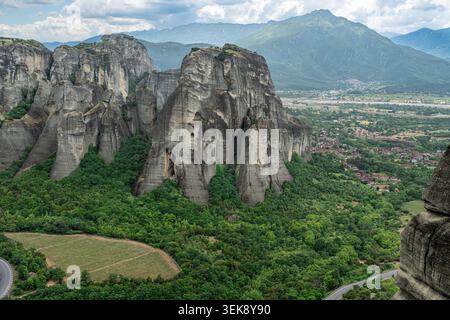 Vue panoramique sur les piliers rocheux de grès des Météores, Grèce, surplombant la plaine de Thessalie sous les nuages d'été spectaculaires. Banque D'Images