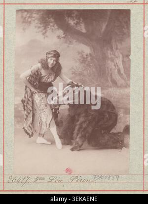 Léa Piron apparaît avec Précheur, qui porte un costume d’ours, dans une photographie de presse studio produite par l’Atelier Nadar pour le drame lyrique le miracle à l’Opéra Garnier à Paris en 1910. Le portrait monochrome se rapporte à la production mise en scène le 30 décembre 1910. Banque D'Images