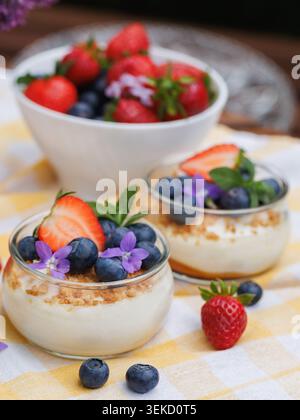 Desserts frais aux baies d'été avec fraises, myrtilles et yaourt dans des pots en verre Banque D'Images