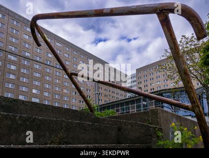 Vue en bas angle d'un escalier altéré et d'une main courante rouillée menant à de grands bâtiments d'après-guerre à Berlin-Lichtenberg. Bloc de béton. Banque D'Images