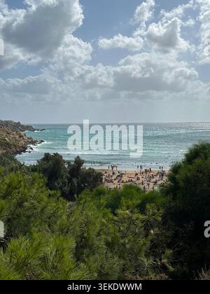 Sandy Beach Cove encadrée par des pins depuis Elevated View Malta Banque D'Images