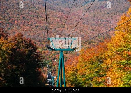 Gondole se déplaçant sur des arbres d'automne colorés avec une chaîne de montagnes en arrière-plan, New Hampshire, États-Unis. Banque D'Images