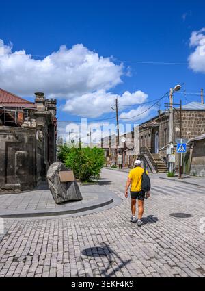 Personne marche dans la rue pavée sous le ciel bleu vif. De vieux bâtiments en pierre bordent le chemin étroit Banque D'Images