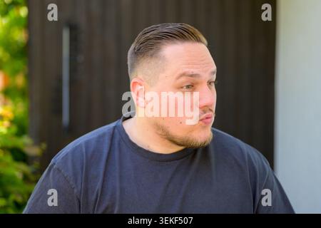 Portrait d'un jeune homme surpris réagissant émotionnellement tout en regardant de côté. Image de style de vie authentique représentant la communication, l'émotion humaine, co Banque D'Images