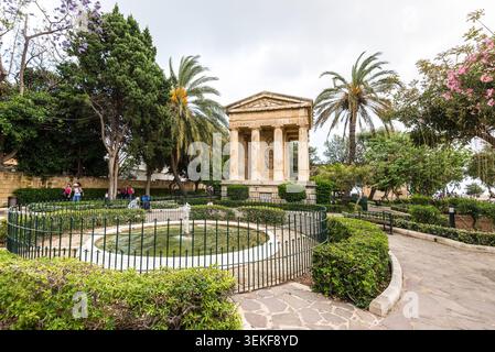 Valette, Malte – 16 mai 2025 : jardins de Lower Barrakka avec le monument néoclassique dédié à Sir Alexander Ball, entouré de palmiers et de la Banque D'Images