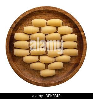 Pipe rigate pâtes disposées en rangées soignées sur une plaque de bois vue d'en haut sur fond blanc. Banque D'Images