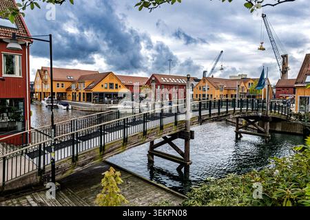 Charmant canal européen bordé de maisons traditionnelles vibrantes et de petits bateaux sous ciel nuageux Banque D'Images