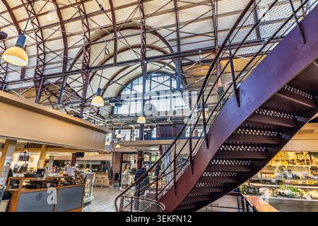 Grand marché alimentaire sous un grand plafond de verre voûté avec lumière naturelle et activité animée Banque D'Images