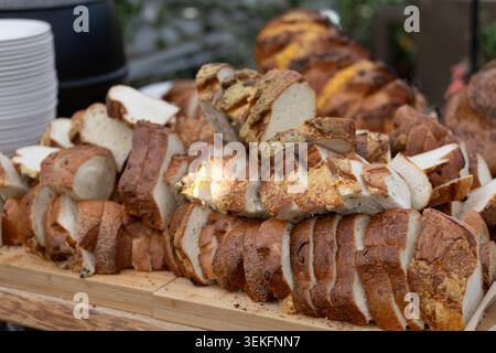 Assortiment de tranches de pain artisanal présentées sur une planche de service en bois en Islande Banque D'Images