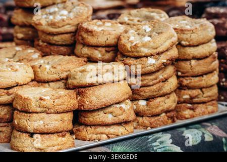 Biscuits gastronomiques fraîchement cuits empilés sur un plateau de boulangerie, avec des croûtes dorées, une texture épaisse et des ingrédients riches, parfaits pour le dessert, la collation et un Banque D'Images
