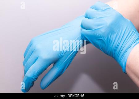 Gros plan des mains portant des gants de protection bleus en nitrile Banque D'Images