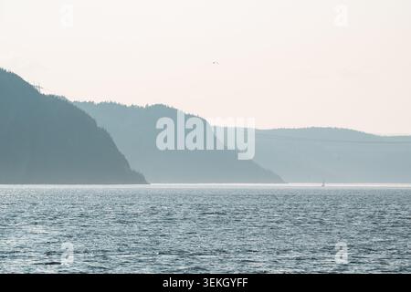 Spectaculaire Hazy Skyline au-dessus de Calm Waters et Rolling Hills en arrière-plan Banque D'Images